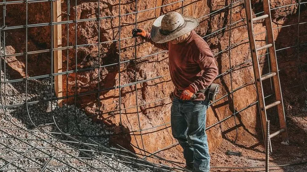 Crew tying the rebar skeleton inside a gunite pool dig